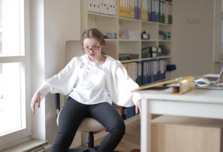 Behavior - Bossy female employee in formal wear sitting on chair in workplace and demonstrating frivolous and unprofessional behavior while looking away
