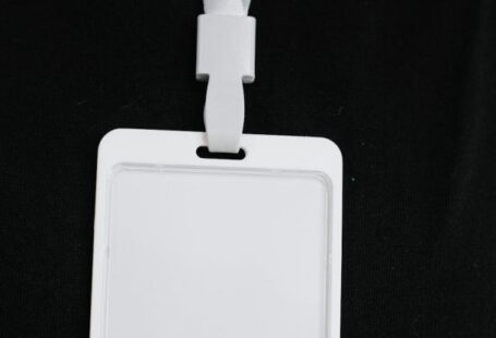 Event Promotion - Plastic name tag with white ribbon and blank paper hanging on black background