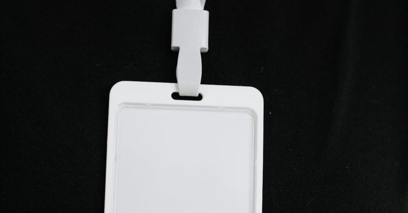Event Promotion - Plastic name tag with white ribbon and blank paper hanging on black background